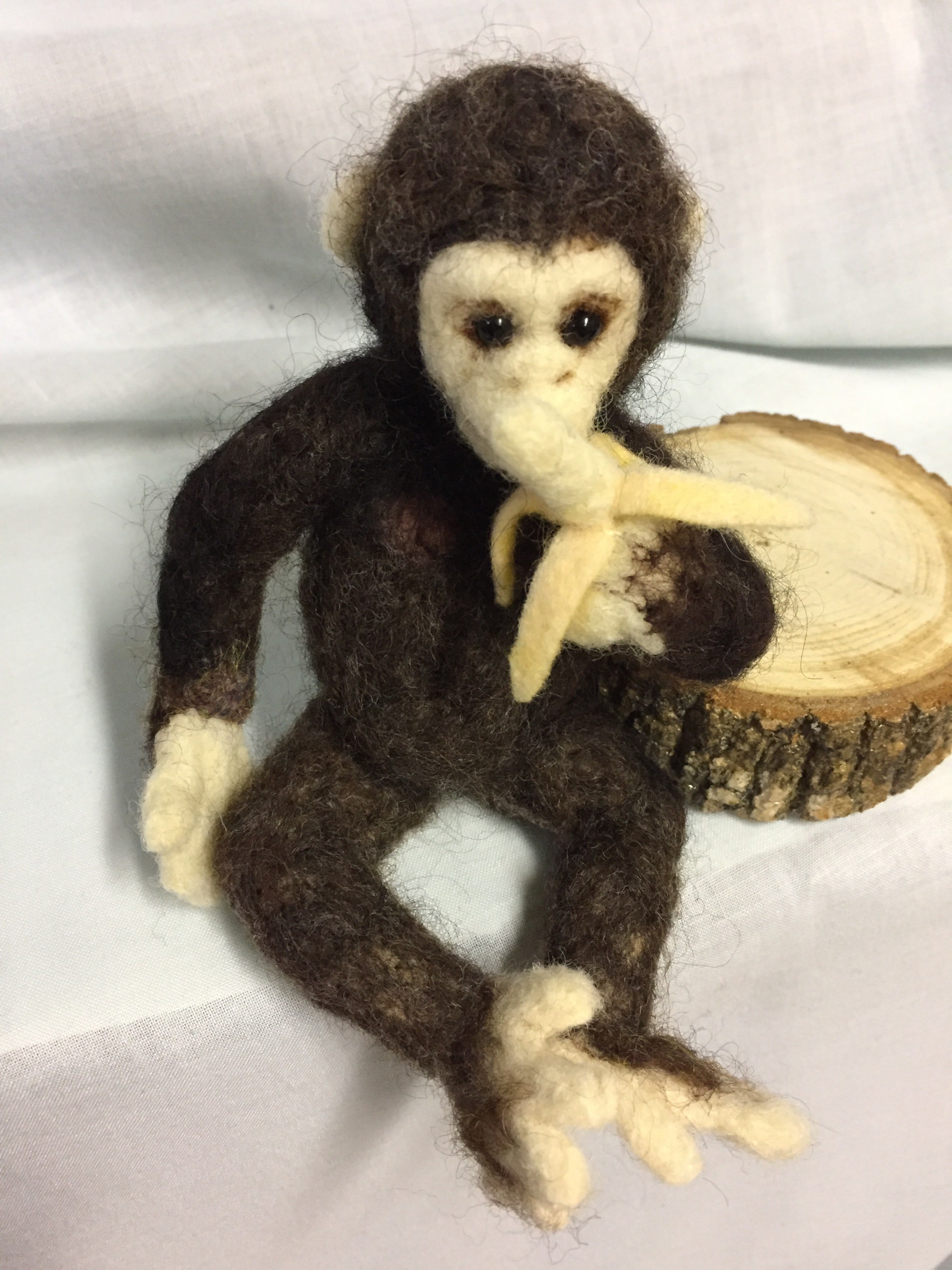 needle felted chimp enjoying his banana.